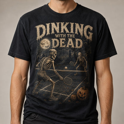  black t-shirt featuring skeletons playing pickleball with distressed vintage Halloween graphics.